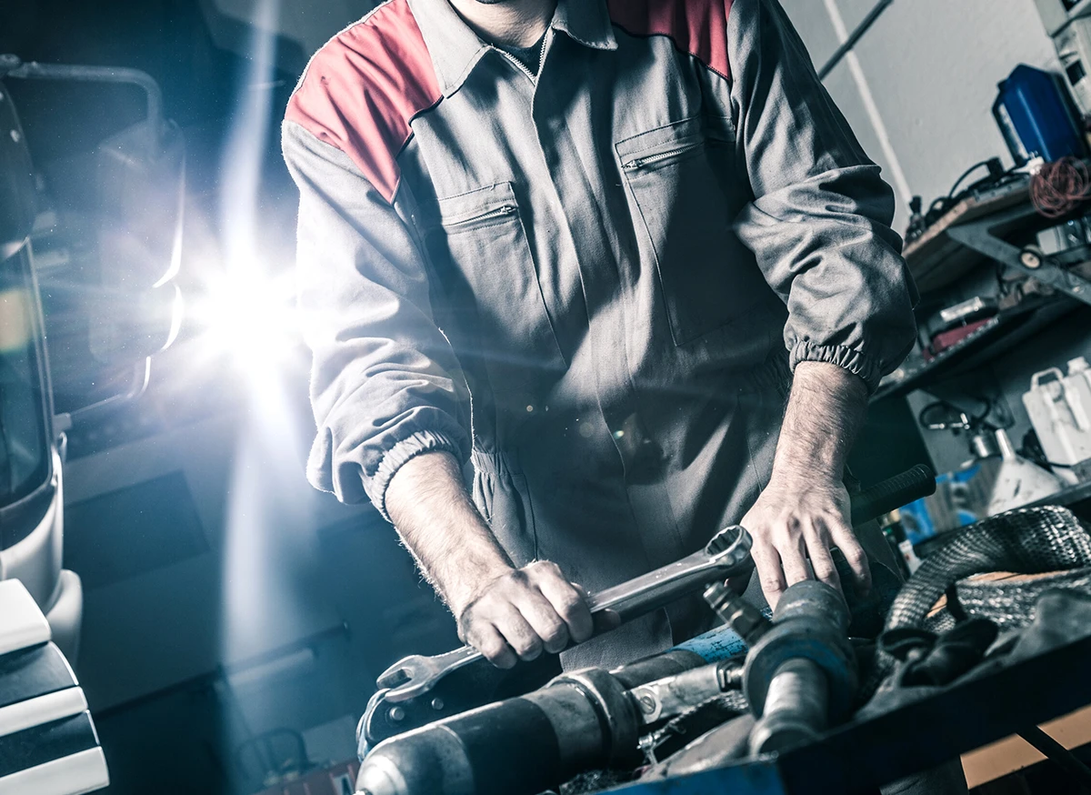 Technicien de Services Mécaniques Heavy-Tech travaillant sur un camion lourd à Mirabel